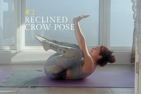 A woman showing reclined crow pose.