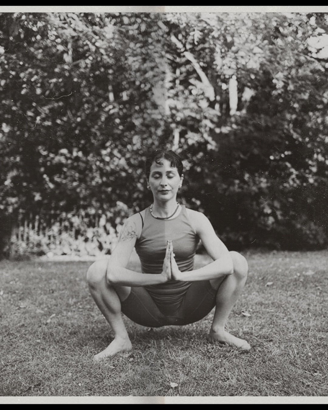 A woman with closed eyes, her one hand on her chest and she is smiling gratefully.